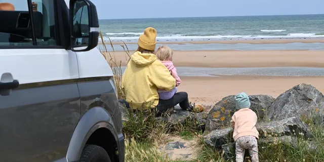 Familie mit Kleinkindern und Camper am Meer