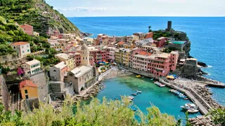 Camping Cinque Terre: A village of the Cinque Terre from above photographed with colorful cottages, a port and the sea in the background.
