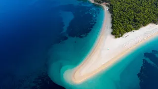 A must on your holiday in Croatia by car by the sea: the beach Zlatni Rat with white sand, which sprinkles into the turquoise blue sea, photographed from the air