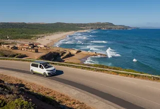 A camper runs a coastal road.