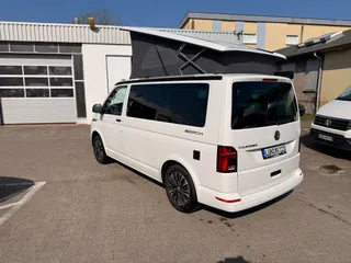 Seitenansicht eines weißen Campervans mit gemütlichem Aufstelldach