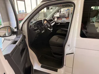 Blick durch die Fahrertür in das Cockpit eines weißen Campervans