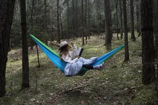 Woman lying in a hammock in the forest