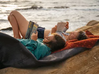 A few friends read on rocks along the coast at their Croatia round trip.