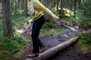 A close-up of a young woman walking through the forest