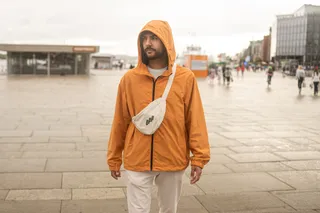 Holiday Easter: A man in oranger rain jacket is in a place in a city in the Netherlands in April