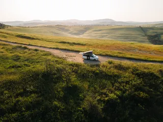 Camper auf einem Weg zwischen Feldern