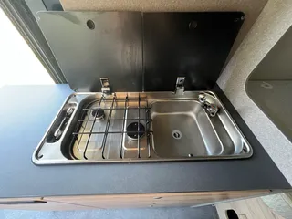 Moderner Kastenwagen mit Küche. Edelstahl-Spüle und Zwei-Flammen-Gasherd perfekt für den Camping-Urlau
