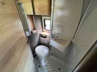 Geräumiger Campervan mit Bad – Blick auf die kompakte Nasszelle inklusive WC, Waschbecken und integrierter Duschwanne.